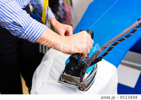 Cleaner in laundry shop ironing jacket 9523898