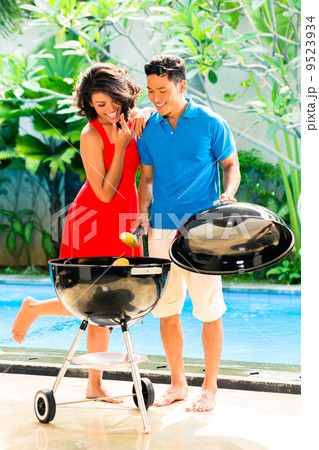 Asian couple having barbecue at the pool 9523934