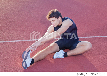 Athlete stretching after jogging in the stadium. 9524569