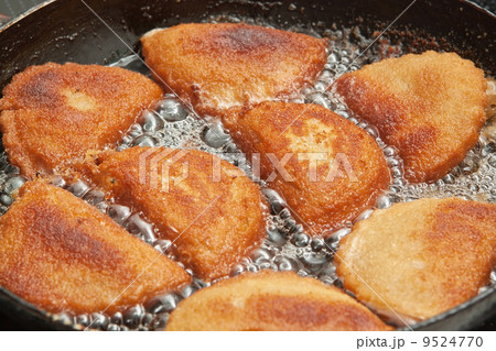 Patties with calamaries in butter in a frying pan. Patties with calamaries in butter in a frying pan. 9524770