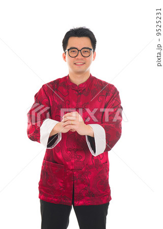 Happy Chinese male in cheongsam hands giving traditional chinese 9525231