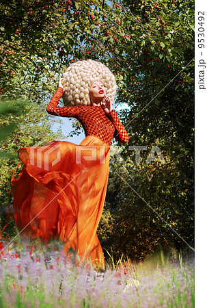 Extravagant Woman in Fluttering Dress and Luxurious Wig with False Hairs 9530492