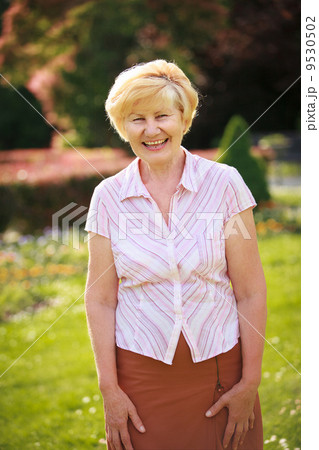 Elegance. Elation. Happy Senior Woman Outside with Toothy Smile 9530502