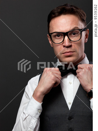 Man with beard correcting his bowtie Man with beard correcting his bowtie 9539162
