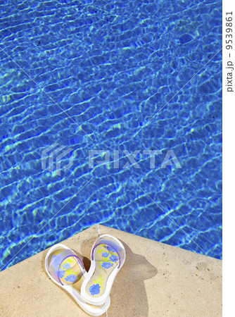 Slippers lies on the brink of pool Slippers lies on the brink of pool 9539861
