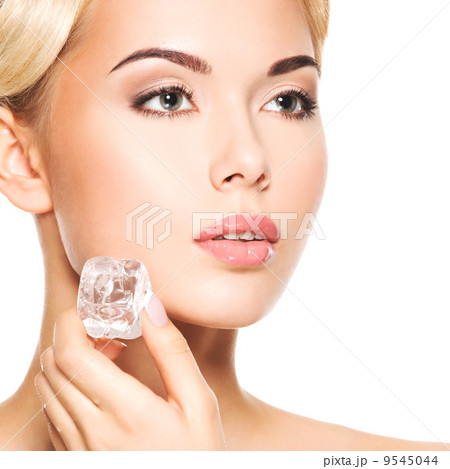 Closeup portrait of beautiful young woman applies the ice to fac Closeup portrait of beautiful young woman applies the ice to fac 9545044