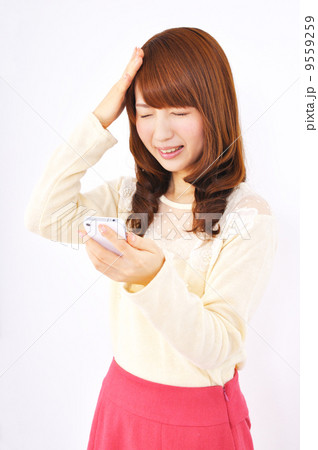 スマートフォンを見て頭を抱える女性 9559259