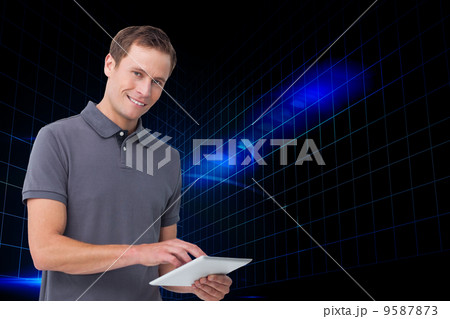 Composite image of smiling young man with tablet computer 9587873