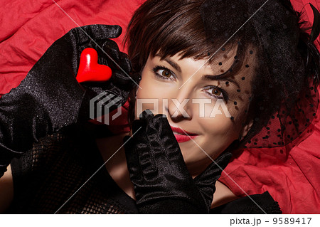 Beautiful smiling woman with red heart in hand Beautiful smiling woman with red heart in hand 9589417