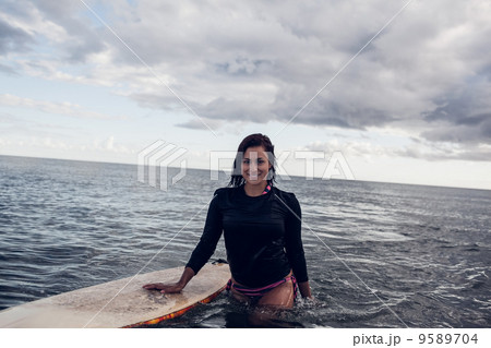 Portrait of a beautiful woman with surfboard in water 9589704