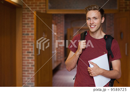 Handsome smiling student standing in hallway Handsome smiling student standing in hallway 9589725