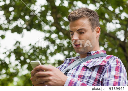 Handsome worried student standing and texting 9589965