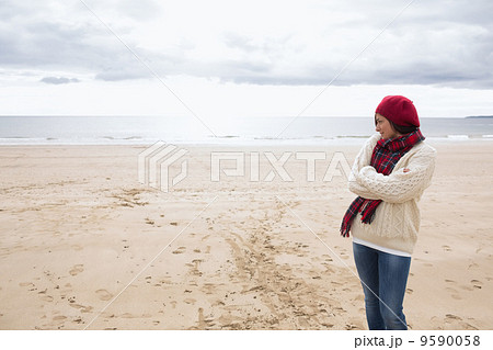 Pretty woman in stylish warm clothing at beach 9590058