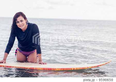 Beautiful young woman with surfboard in water Beautiful young woman with surfboard in water 9590650