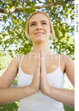 Front view of young woman meditating in sukhasana pose 9590708