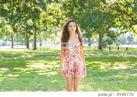 Stylish day dreaming brunette walking on grass Stylish day dreaming brunette walking on grass 9590770