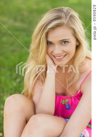 Portrait of cute young woman sitting on a lawn Portrait of cute young woman sitting on a lawn 9590829