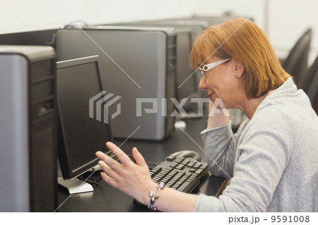 Annoyed mature student working on computer Annoyed mature student working on computer 9591008