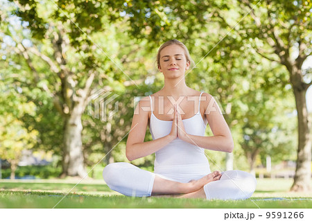 Content peaceful woman meditating sitting on an exercise mat Content peaceful woman meditating sitting on an exercise mat 9591266