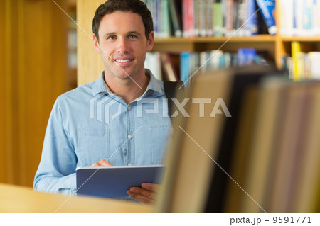 Smiling mature student with tablet PC in library Smiling mature student with tablet PC in library 9591771
