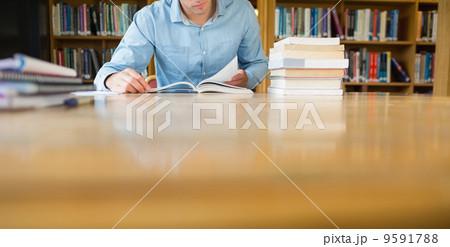 Mid section of a mature student at library desk Mid section of a mature student at library desk 9591788