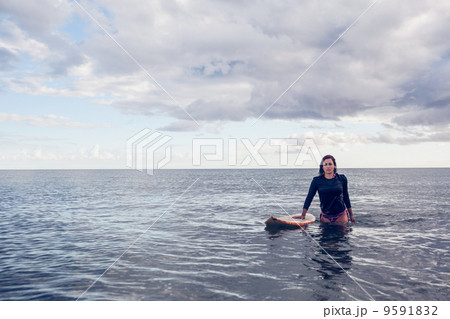 Portrait of a beautiful young woman with surfboard in water 9591832