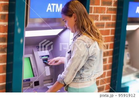 Pretty brunette student withdrawing cash Pretty brunette student withdrawing cash 9591912