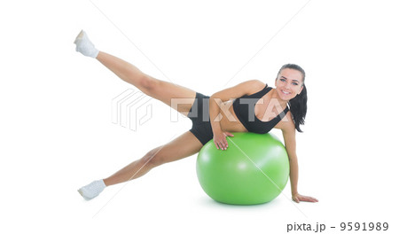 Content active woman doing an exercise on a green fitness ball 9591989
