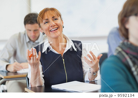 Laughing female mature woman sitting in classroom Laughing female mature woman sitting in classroom 9592134
