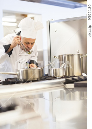 Concentrating head chef tasting food from ladle Concentrating head chef tasting food from ladle 9592180