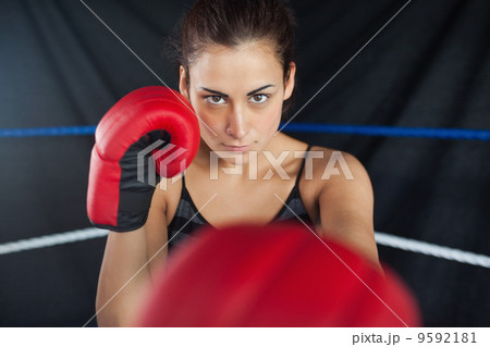 Beautiful woman in red boxing gloves in the ring Beautiful woman in red boxing gloves in the ring 9592181