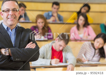 Elegant teacher with students sitting at lecture hall Elegant teacher with students sitting at lecture hall 9592418