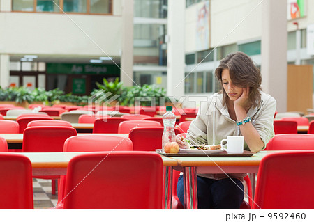 Sad student in the cafeteria with food tray 9592460