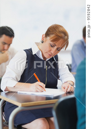 Concentrated female mature student sitting in classroom Concentrated female mature student sitting in classroom 9592842