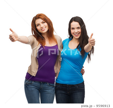 two smiling girls showing thumbs up two smiling girls showing thumbs up 9596913