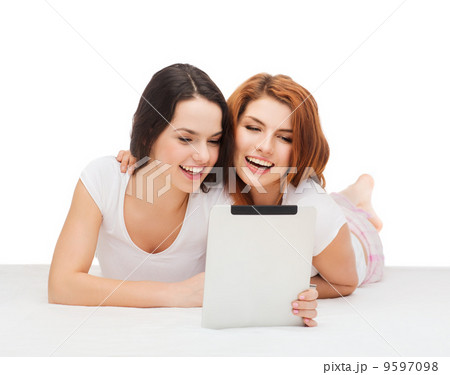 two smiling teenage girsl with tablet pc computer 9597098