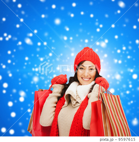smiling woman in warm clothers with shopping bags 9597615
