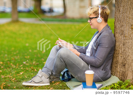 boy with headphones, tablet pc, books and coffee boy with headphones, tablet pc, books and coffee 9597746
