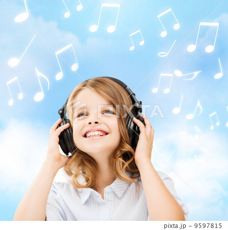 smiling little girl with headphones at home 9597815