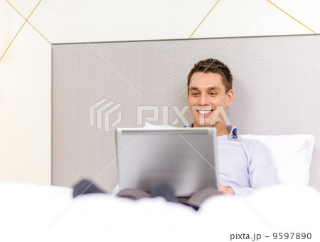 happy businesswoman with laptop in hotel room 9597890