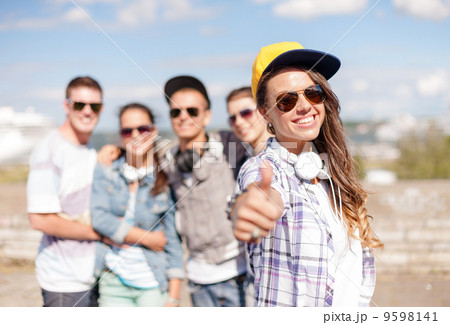 teenage girl with headphones and friends outside 9598141