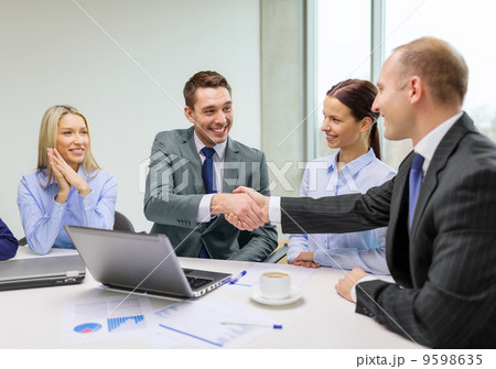 two businessman shaking hands in office 9598635