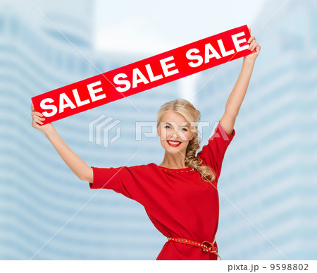 smiling woman in dress with red sale sign 9598802