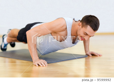 smiling man doing push-ups in the gym smiling man doing push-ups in the gym 9599992