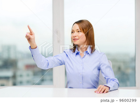 smiling woman pointing to something imaginary 9600299