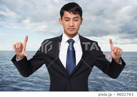 Composite image of unsmiling businessman holding 9602763