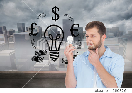 Composite image of handsome model holding a bulb Composite image of handsome model holding a bulb 9603264