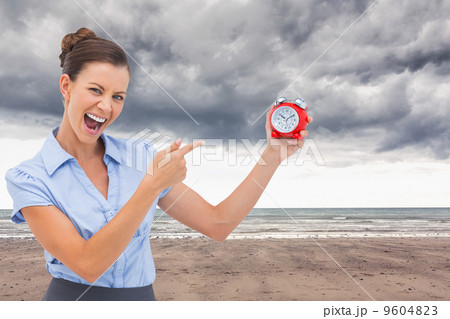 Composite image of businesswoman indicating alarm clock Composite image of businesswoman indicating alarm clock 9604823