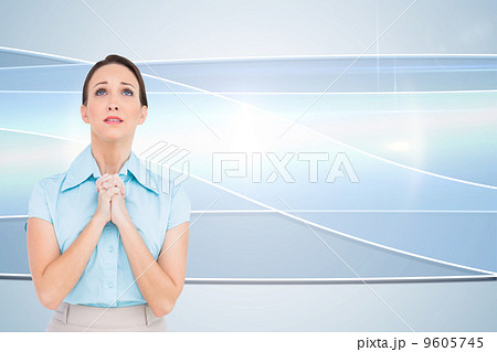 Composite image of troubled young businesswoman praying 9605745