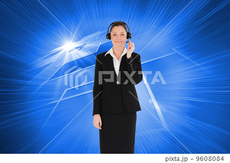 Composite image of good looking woman in suit using headphones a 9608084